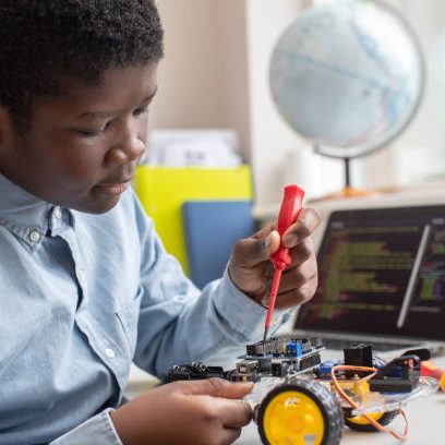 Male High School Pupil Building Robot Car In Science Lesson